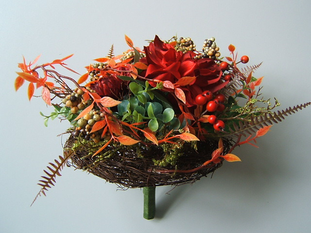Herbstarrangement auf Reisigmanschette mit Blumen, Blättern und Beeren